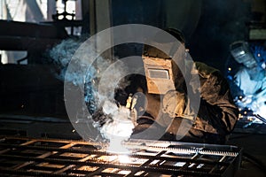 Closeup worker in a mask doing the welding in a workshop