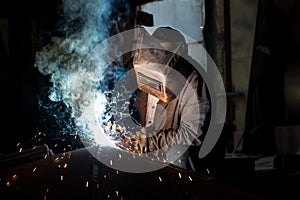 Closeup worker in a mask doing the welding in a workshop