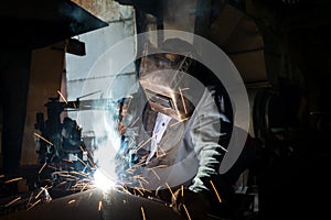 Closeup worker in a mask doing the welding in a workshop