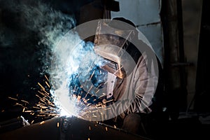 Closeup worker in a mask doing the welding in a workshop
