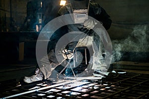 Closeup worker in a mask doing the welding in a workshop