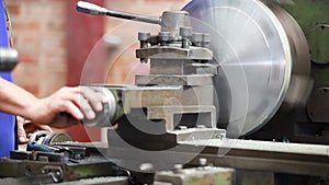 Closeup of worker operating milling machine center in tool manufacture workshop.