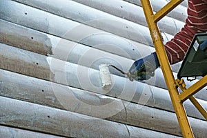 Closeup of a worker`s hand painting the wall with a cushion.