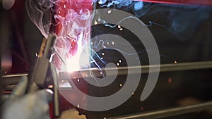 Closeup worker using electric arc welding machine to weld steel by manual skill labor in slow motion.