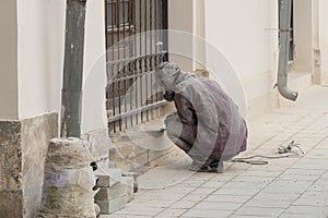 Closeup of a worker who processes granite using a grinding machine. Dust and shards fly to the sides