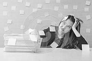 Closeup working woman are boring from hard work and pile of work paper in front of her in work concept on blurred wooden desk and