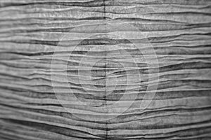 Closeup of a wrinkled and backlit paper background in black and white