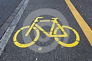 Yellow bicycle sign path on the road