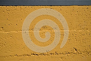 closeup of a yellow cement wall with cracks and crevices