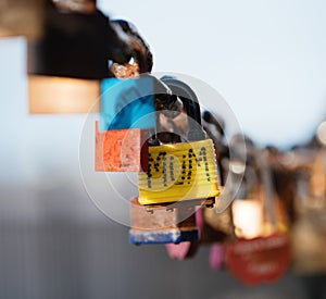 Closeup of a padlock hanging on chain link of the bridge / Fence