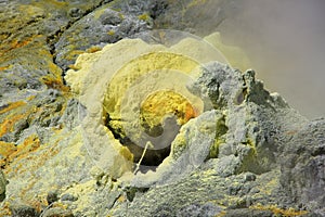 Closeup of a yellow sulphuric surface with crystels on the floor