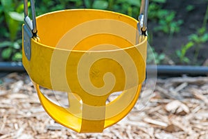 Closeup of yellow toddler baby swing part of a childrens swing set