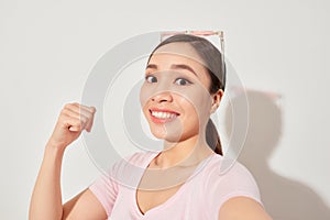 Closeup of young Asian beautiful woman smilling and taking selfie on white background