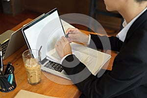 Closeup, Young asian businessman in black suit working on laptop