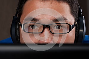 Closeup of young asian man playing on computer