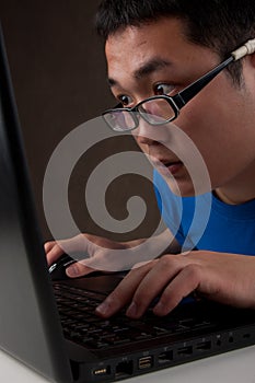 Closeup of young asian man working on laptop