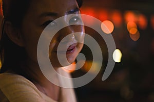 Closeup of a young beautiful Asian woman in the evening, beautiful bokeh