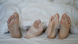 Closeup of young beautiful and loving couple play and dance their feet