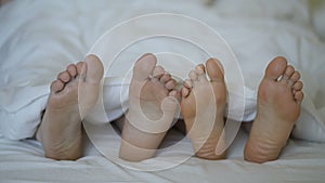 Closeup of young beautiful and loving couple play and dance their feet