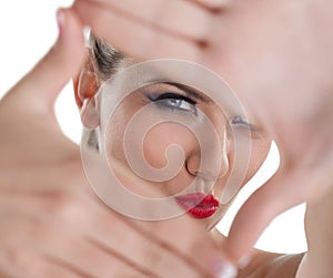 Closeup of young beautiful woman making frame with her hands