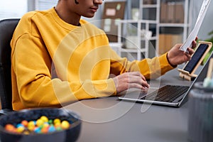Closeup of young black man working or studying at home office workplace