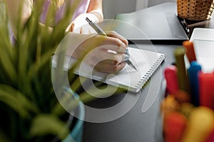 Closeup of young businesswoman working at modern office making notes