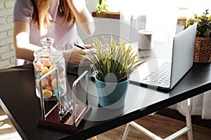 Closeup of young businesswoman working at modern office making notes