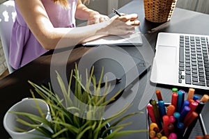 Closeup of young businesswoman working at modern office making notes