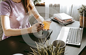 Closeup of young businesswoman working at modern office making notes