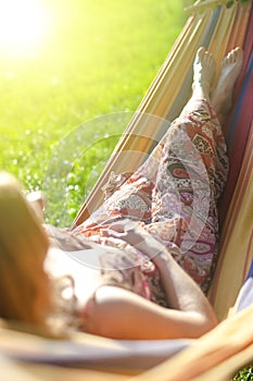 Closeup of Young Caucasian Blond Girl Relaxing In Hammock In Green Forest Outdoors