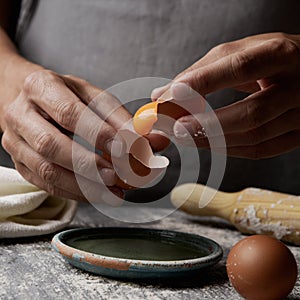 Young man separating the yolk of an egg