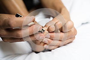 Young caucasian man cutting his toenails photo