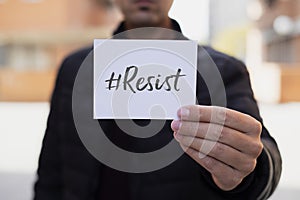 Man showing a note with the hashtag resist photo