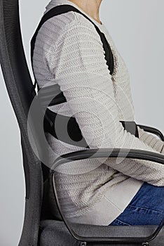 Man wearing a posture corrector while sitting photo