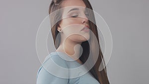 Closeup of young caucasian woman with long hair moved by wind slowly blye eyed model portrait,