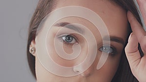 Closeup of young caucasian woman with long hair moved by wind slowly blye eyed model portrait,