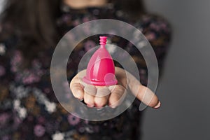 Woman showing a pink menstrual cup photo
