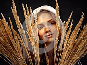 Closeup young charming redhead girl in image of medieval person in renaissance style in ears of wheat. Art, beauty