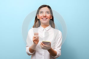 Closeup young cheerful businesswoman with beautiful healthy smile holding pen making new ideas notes and interestedly