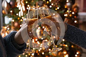 Closeup young couple clinking glasses with champagne, new year celebration.