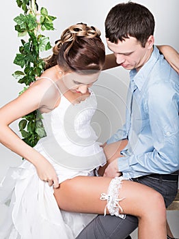 Closeup of a young couple in love, man stands with his back to the camera, she bites his ear. Playful couple. her legs