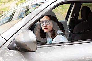 Closeup of a young girl driver. Girl learns to drive a car. Fear of traffic, traffic jams. Stress from driving a car