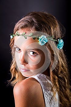 Closeup of a young girl with flower tiara and sober look