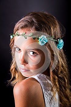 Closeup of a young girl with flower tiara and sober look photo