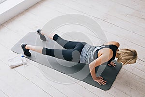 Closeup of young happy attractive woman doing push ups or press ups exercise