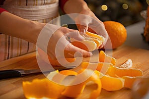 Closeup on young housewife dividing orange slices