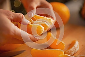 Closeup on young housewife dividing orange slices