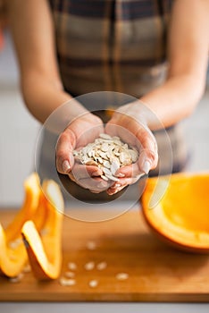 Closeup on young housewife showing pumpkin seeds