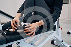 Closeup of young lady wears special rehab shoes on her feet to practice on recreational simulator