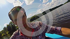 Closeup young man paddling kayak on river, action camera, selfie